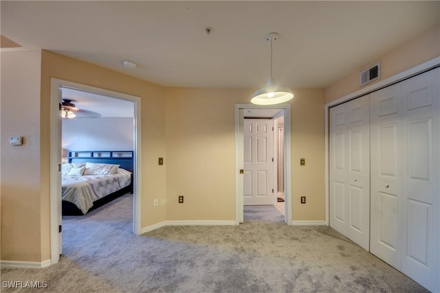 bedroom with baseboards, visible vents, and light colored carpet