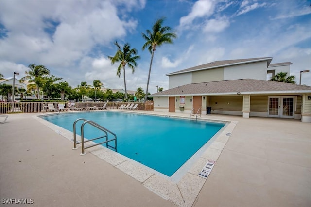 community pool with a patio, french doors, and fence