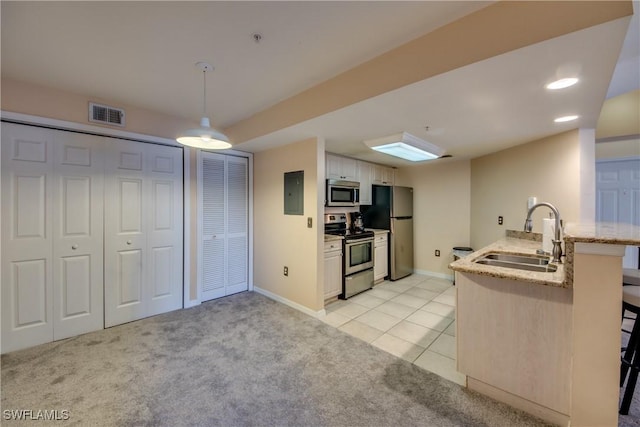 kitchen with stainless steel appliances, light colored carpet, visible vents, a sink, and a peninsula