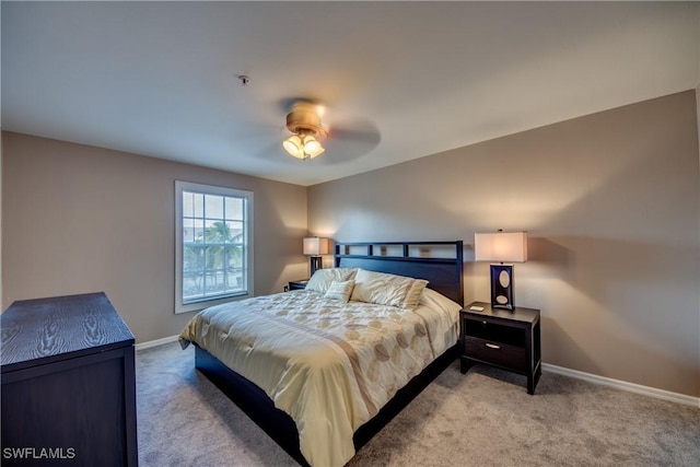 bedroom with a ceiling fan, light carpet, and baseboards