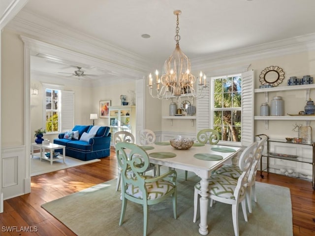 dining space with ceiling fan with notable chandelier, hardwood / wood-style flooring, and ornamental molding