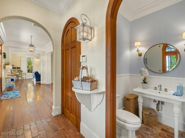 bathroom featuring toilet and ornamental molding