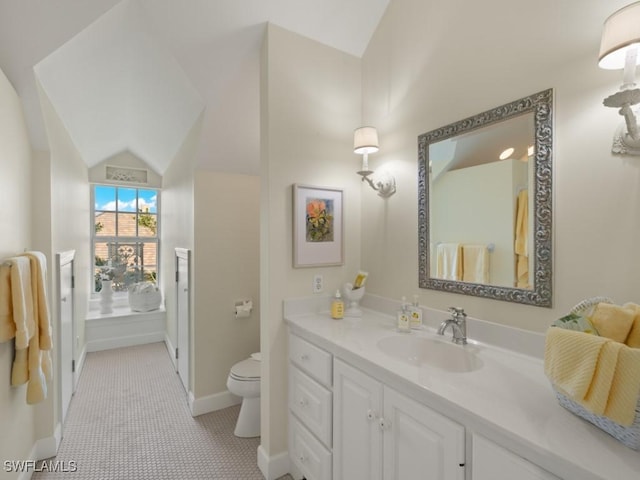 bathroom with tile patterned flooring, vanity, toilet, and lofted ceiling