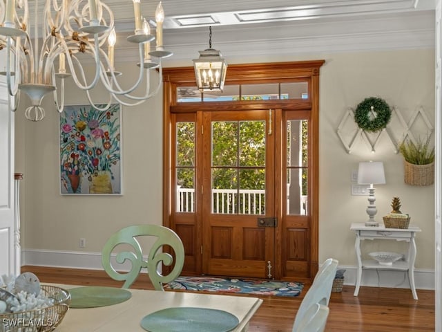 dining space featuring a chandelier, wood-type flooring, and ornamental molding