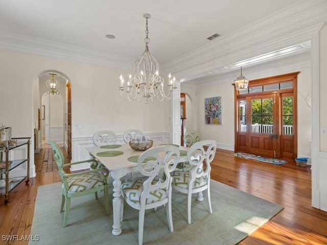 dining room with a chandelier, crown molding, and light hardwood / wood-style flooring