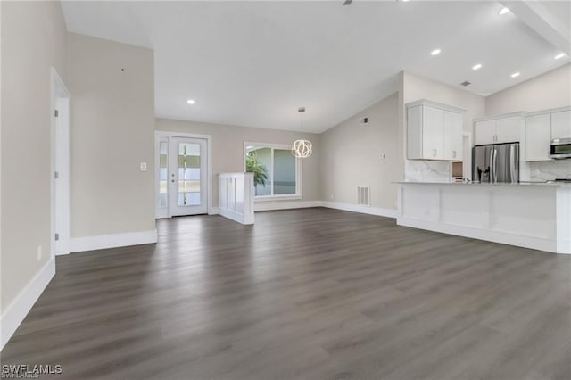 unfurnished living room featuring a notable chandelier, dark hardwood / wood-style flooring, and vaulted ceiling