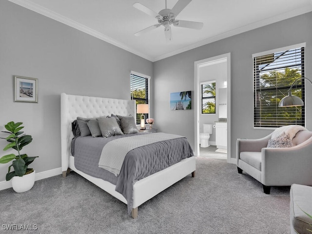 bedroom featuring carpet flooring, multiple windows, ensuite bath, and ceiling fan