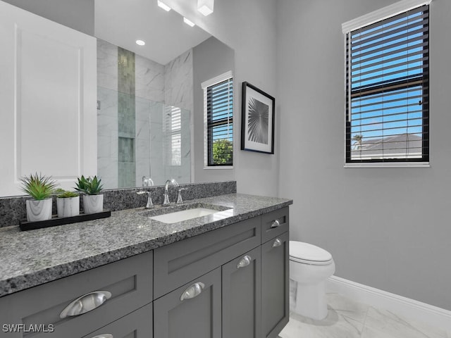 bathroom with vanity, toilet, and a shower with door