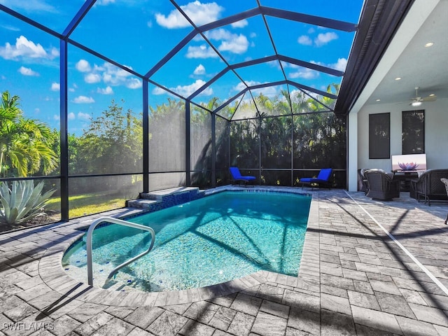 view of swimming pool featuring ceiling fan, a patio, and glass enclosure