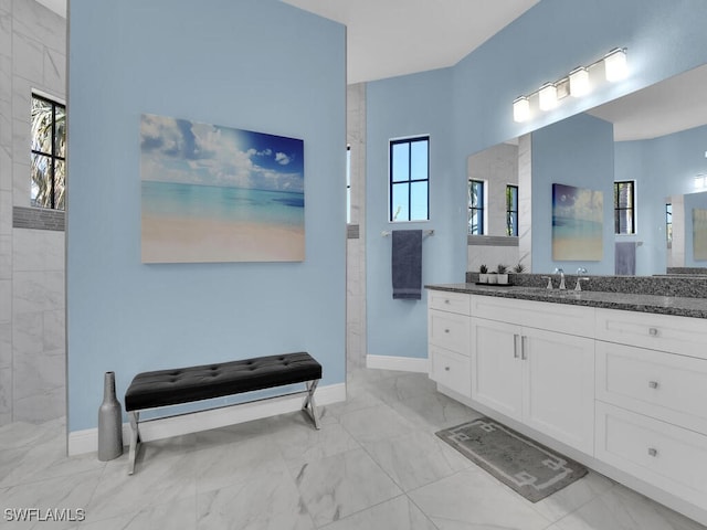 bathroom featuring tiled shower, vanity, and a wealth of natural light