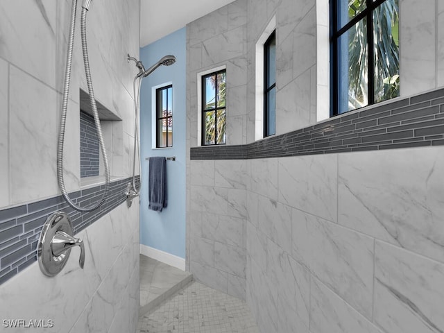 bathroom featuring tiled shower and tile walls