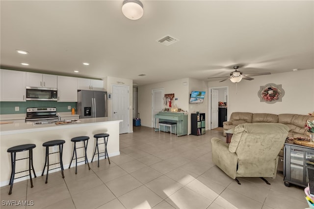 tiled living room featuring ceiling fan