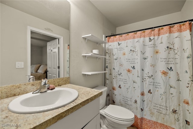 bathroom featuring vanity, curtained shower, and toilet