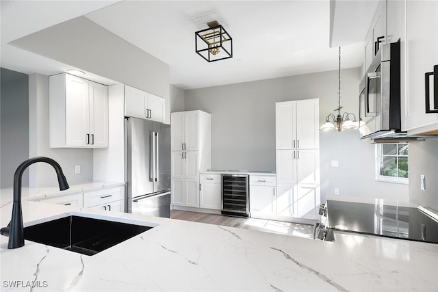 kitchen with wine cooler, sink, white cabinets, and appliances with stainless steel finishes