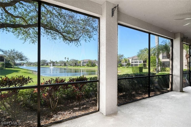 sunroom featuring a water view