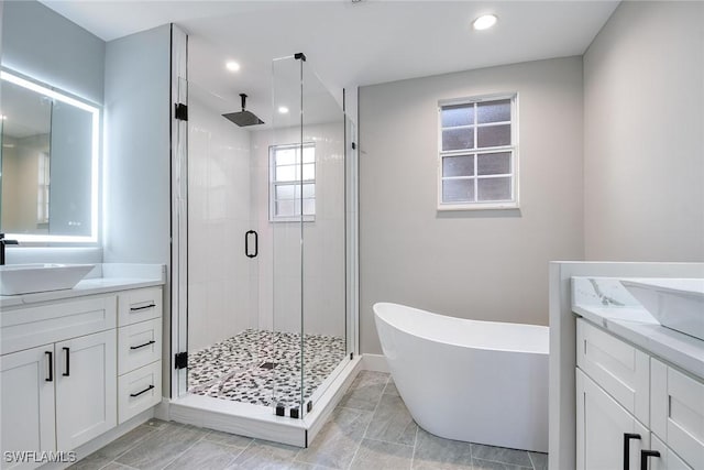 bathroom with vanity and shower with separate bathtub