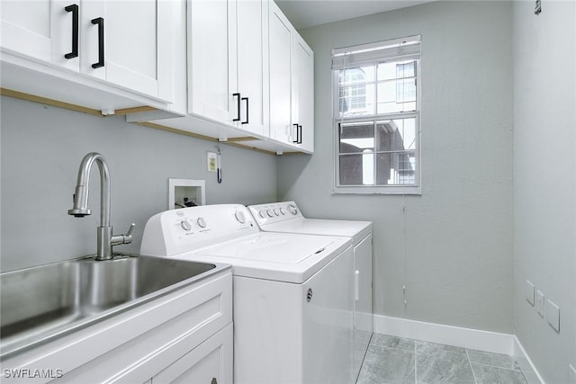 washroom with cabinets, sink, light tile patterned floors, and washer and dryer