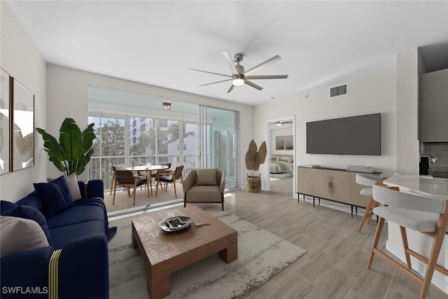 living room featuring ceiling fan and light hardwood / wood-style floors