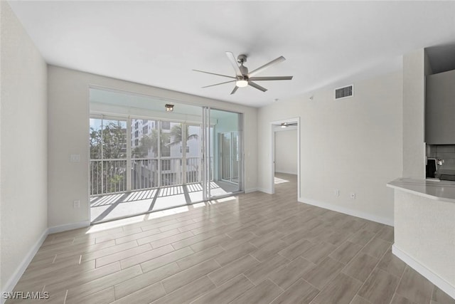 unfurnished living room featuring ceiling fan and a large fireplace