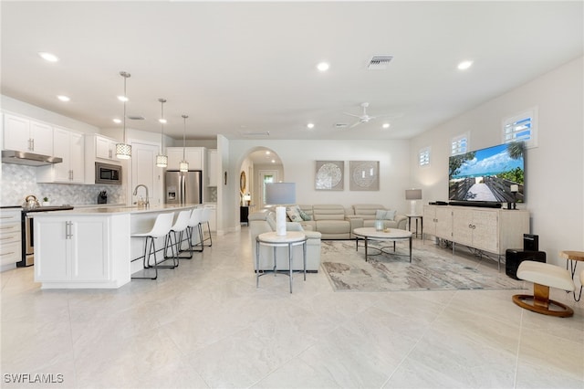 living room with ceiling fan and sink