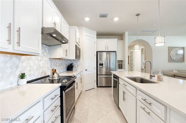 kitchen with sink, ventilation hood, decorative light fixtures, white cabinets, and appliances with stainless steel finishes