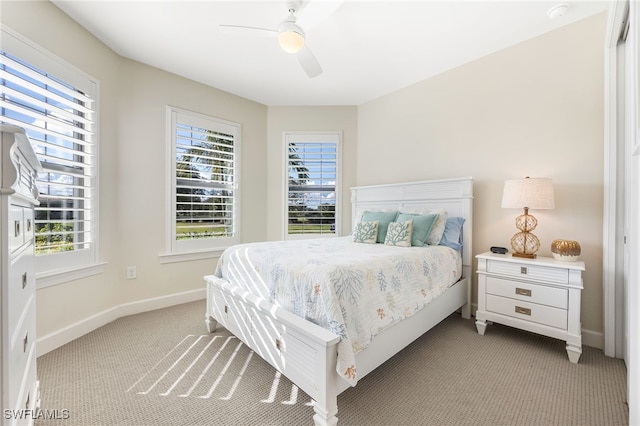 bedroom featuring light carpet, multiple windows, and ceiling fan