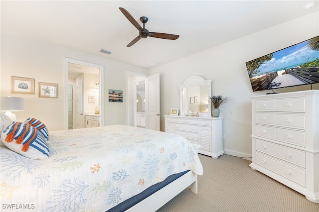 carpeted bedroom featuring ceiling fan and ensuite bath