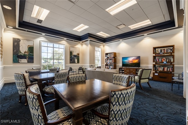 carpeted dining area featuring a tray ceiling and crown molding