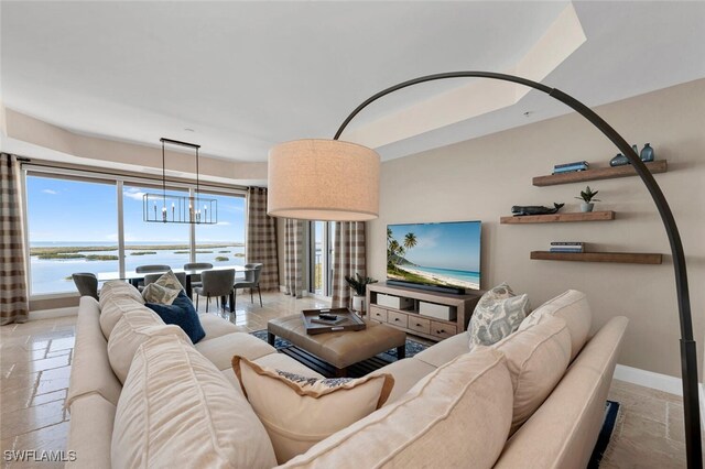 living room featuring a water view and an inviting chandelier