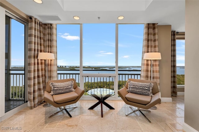 sunroom featuring a water view