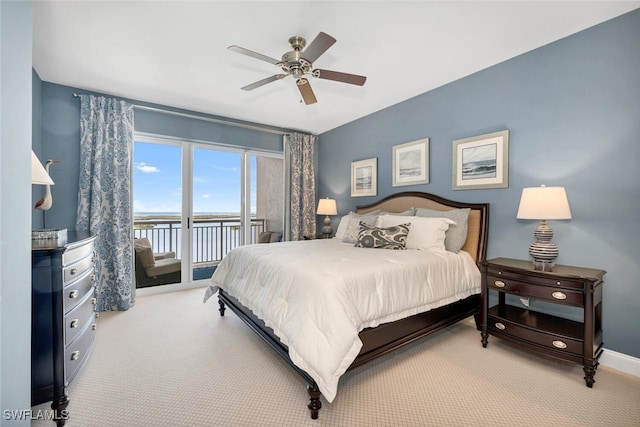 bedroom featuring carpet flooring, access to outside, ceiling fan, and a water view