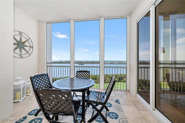 sunroom featuring a water view