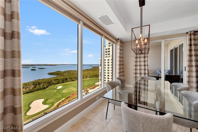 sunroom with a water view and a chandelier