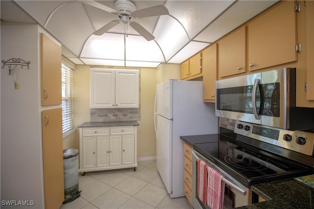 kitchen featuring backsplash, ceiling fan, dark stone countertops, appliances with stainless steel finishes, and light tile patterned flooring