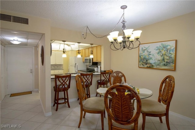 dining room with light tile patterned floors, a chandelier, and a textured ceiling