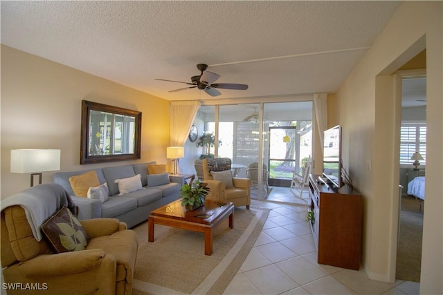 tiled living room featuring ceiling fan, a healthy amount of sunlight, and a textured ceiling