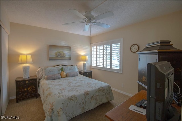 carpeted bedroom with ceiling fan and a textured ceiling