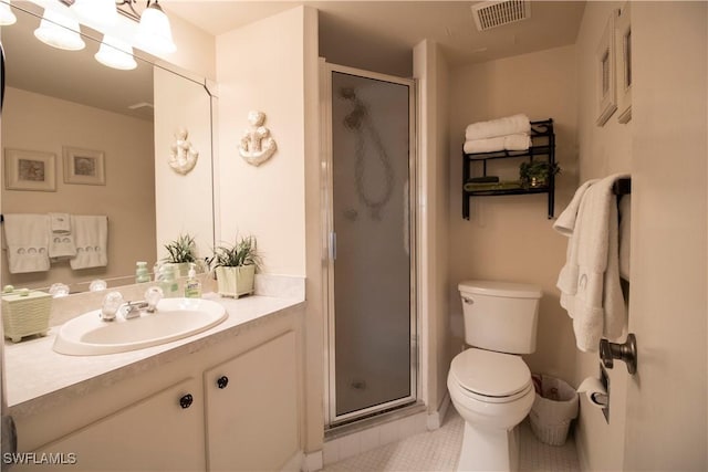 bathroom featuring tile patterned floors, vanity, toilet, and a shower with shower door