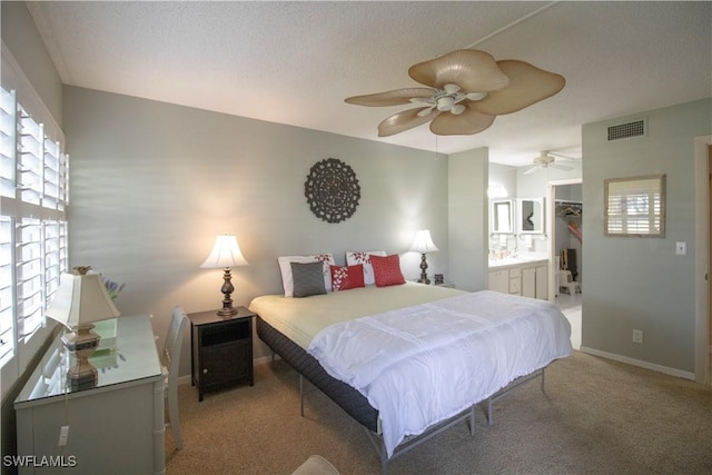 carpeted bedroom featuring ceiling fan, a spacious closet, a textured ceiling, connected bathroom, and a closet