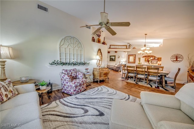 living room featuring wood-type flooring and ceiling fan with notable chandelier