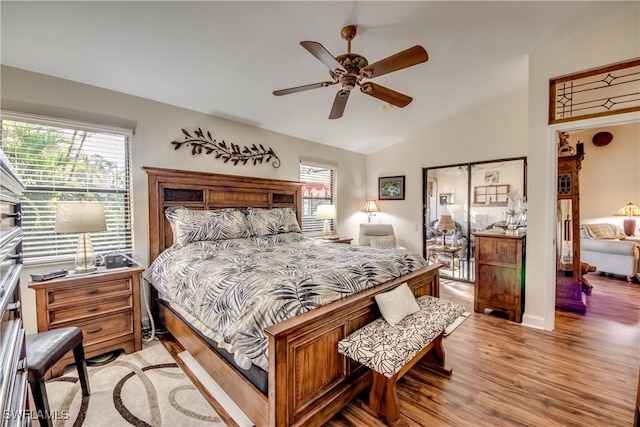 bedroom featuring ceiling fan, light hardwood / wood-style flooring, and lofted ceiling