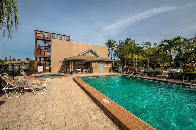 view of pool with a patio and a hot tub