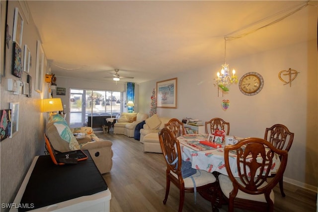 dining area featuring hardwood / wood-style flooring and ceiling fan with notable chandelier