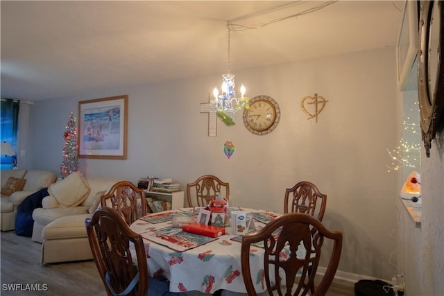 dining space featuring hardwood / wood-style floors and a chandelier