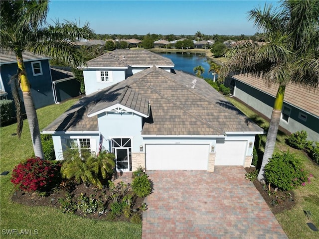 view of front of property featuring a garage and a water view