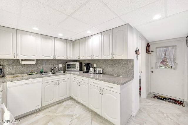 kitchen with dishwasher, white cabinets, tasteful backsplash, and sink