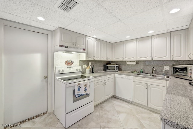 kitchen with sink, backsplash, white appliances, white cabinets, and custom range hood