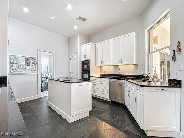 kitchen with dishwasher, dark stone counters, sink, double oven, and white cabinetry