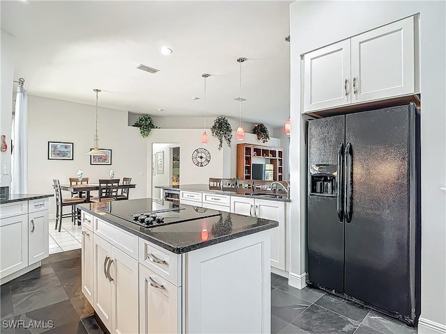 kitchen featuring black appliances, decorative light fixtures, a kitchen island, and white cabinets