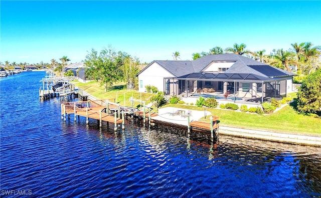 rear view of property featuring glass enclosure and a water view